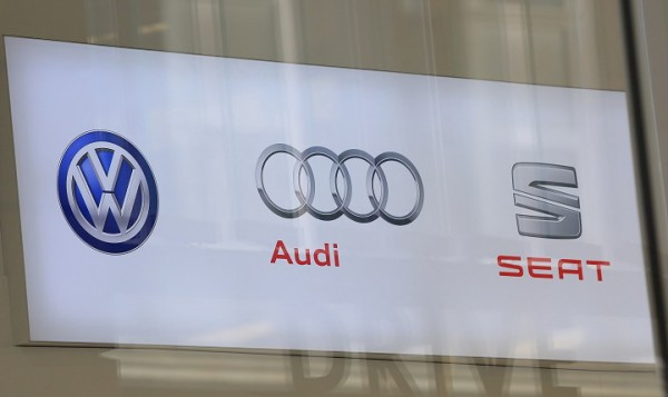 The logos of Volkswagen AG (VW), left, Audi AG, center, and Seat sit on a sign inside the Volkswagen Group Forum in Berlin, Germany, on Friday, Jan. 8, 2016. Volkswagen may buy back tens of thousands of cars with diesel engines that can't be easily fixed to comply with U.S. emissions standards as part of its efforts to satisfy the demands of regulators, according to two people familiar with the matter. Photographer: Krisztian Bocsi/Bloomberg