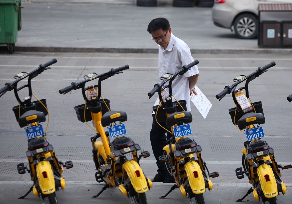 6月22日，广西柳州市融水苗族自治县县城街头的共享电单车，吸引着好奇的路人驻足观看。